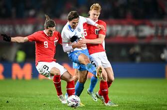 epa10316911 Federico Chiesa (C) of Italy in action against Marcel Sabitzer (L) of Austria and Nicolas Seiwald of Austria during the international friendly soccer match between Austria and Italy in Vienna, Austria, 20 November 2022.  EPA/CHRISTIAN BRUNA