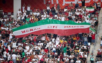 DOHA, QATAR - NOVEMBER 21:  Iranian fans hold up signs "Woman Life Freedom" during the FIFA World Cup Qatar 2022 Group B match between England and IR Iran at Khalifa International Stadium on November 21, 2022 in Doha, Qatar. (Photo by Juan Luis Diaz/Quality Sport Images/Getty Images)