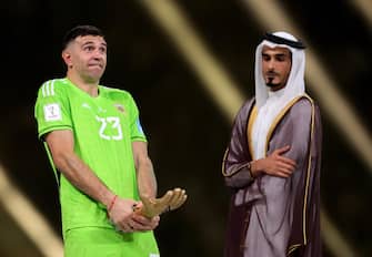 epa10373090 Argentina's goalkeeper Emiliano Martinez (L) poses after receiving the Golden Glove award as best goalkeeper of the tournament after the FIFA World Cup 2022 Final between Argentina and France at Lusail stadium, Lusail, Qatar, 18 December 2022.  EPA/Friedemann Vogel