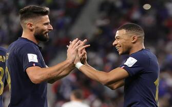 epa10348264 Kylian Mbappe (R) of France celebrates with teammate Olivier Giroud after scoring the 2-0 lead during the FIFA World Cup 2022 round of 16 soccer match between France and Poland at Al Thumama Stadium in Doha, Qatar, 04 December 2022.  EPA/Friedemann Vogel