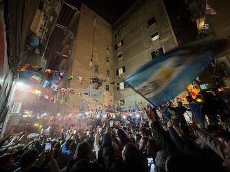 Napoletani tifosi dell Argentina festeggiano sotto il murales di Maradona ai Quartieri Spagnoli la vittoria della nazionale di calcio Argentina ai mondiali del Qatar, Napoli, 18 dicembre 2022. ANSA/CESARE ABBATE