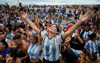 TOPSHOT - Fans of Argentina react while watching the live broadcast of the Qatar 2022 World Cup final football match between France and Argentina at the Copacabana beach in Rio de Janeiro, Brazil, on December 18, 2022. (Photo by MAURO PIMENTEL / AFP) (Photo by MAURO PIMENTEL/AFP via Getty Images)