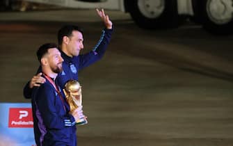 epa10374427 Lionel Messi (L) of the Argentina national soccer team and head coach Lionel Scaloni pose with the trophy of Qatar 2022 World Cup upon ther arrival to the International Airport of Ezeiza, some 22km of Buenos Aires, Argentina, 20 December 2022.  EPA/RAUL MARTINEZ