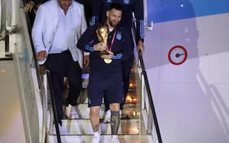 epa10374425 Lionel Messi of the Argentina national soccer team descends a plane with the trophy of Qatar 2022 World Cup upon the team's arrival to the International Airport of Ezeiza, some 22km of Buenos Aires, Argentina, 20 December 2022.  EPA/RAUL MARTINEZ