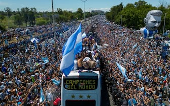 Argentina's players celebrate on board a bus with a sign reading "World Champions" with supporters after winning the Qatar 2022 World Cup tournament as they tour through Buenos Aires' downtown on December 20, 2022. - Millions of ecstatic fans are expected to cheer on their heroes as Argentina's World Cup winners led by captain Lionel Messi began their open-top bus parade of the capital Buenos Aires on Tuesday following their sensational victory over France. (Photo by Tomas CUESTA / AFP) (Photo by TOMAS CUESTA/AFP via Getty Images)