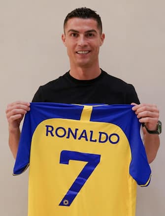 epa10383111 A handout photo made available by the Saudi Al-Nassr Club on 30 December shows Portuguese soccer player Cristiano Ronaldo posing for a photograph with the club's jersey after signing with Al-Nassr, in Riyadh, Saudi Arabia. Al-Nassr Club announced on 30 December that Ronaldo signed a contract that runs untill 2025.  EPA/AL-NASSR CLUB HANDOUT  HANDOUT EDITORIAL USE ONLY/NO SALES