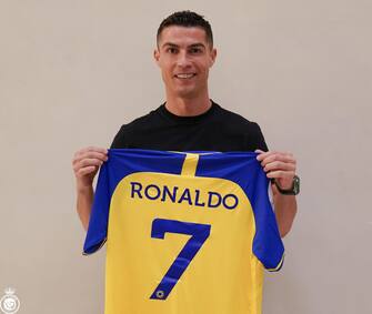 epa10383111 A handout photo made available by the Saudi Al-Nassr Club on 30 December shows Portuguese soccer player Cristiano Ronaldo posing for a photograph with the club's jersey after signing with Al-Nassr, in Riyadh, Saudi Arabia. Al-Nassr Club announced on 30 December that Ronaldo signed a contract that runs untill 2025.  EPA/AL-NASSR CLUB HANDOUT  HANDOUT EDITORIAL USE ONLY/NO SALES