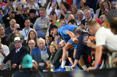 epa10438046 Novak Djokovic of Serbia is assisted from the players box after winning the men s singles final against Stefanos Tsitsipas of Greece at the 2023 Australian Open tennis tournament in Melbourne, Australia, 29 January 2023.  EPA/James Ross AUSTRALIA AND NEW ZEALAND OUT
