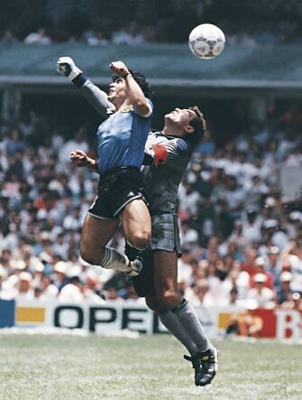 MEXICO CITY, MEXICO - JUNE 22: Diego Maradona of Argentina uses his hand to score the first goal of his team during a 1986 FIFA World Cup Quarter Final match between Argentina and England at Azteca Stadium on June 22, 1986 in Mexico City, Mexico. Maradona later claimed that the goal was scored by 'The Hand Of God'. (Photo by Archivo El Grafico/Getty Images)