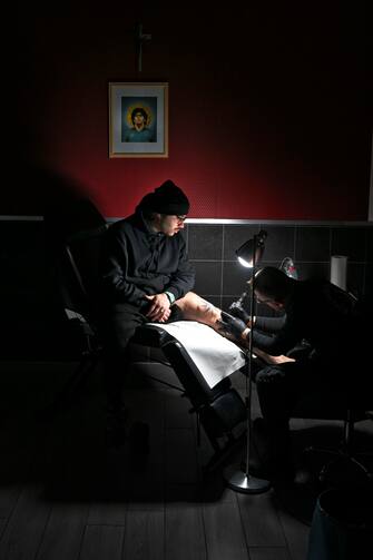 Il tatuatore Salvatore Russo impegnato nel suo laboratorio nella realizzazione di uno scudetto con il numero 3 richiesto da un tifoso del Napoli, 16 febbraio 2023.
ANSA / CIRO FUSCO