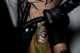 Il tatuatore Salvatore Russo impegnato nel suo laboratorio nella realizzazione di uno scudetto con il numero 3 richiesto da un tifoso del Napoli, 16 febbraio 2023.
ANSA / CIRO FUSCO
