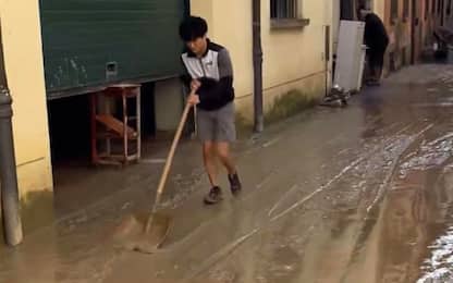 Il pilota di F1 Tsunoda spala il fango a Faenza colpita dall'alluvione