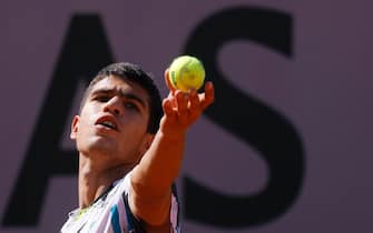 epa08686266 Carlos Alcaraz of Spain in action against Aleksandar Vukic of Australia during their men's 1st round qualification match during the French Open tennis tournament at Roland Garros in Paris, France, 21 September 2020. Roland Garros runs from 21 to 11 October 2020, with one week qualification.  EPA/YOAN VALAT