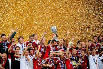 120655346 Football team players of AC Milan celebrate with the trophy after winning the Italian Super Cup 2011 match against Inter Milan at China's National Stadium, known as Bird's Nest, in Beijing on August 6, 2011. AC Milan beat Inter Milan 2-1. AFP PHOTO/Franko Lee (Photo credit should read Franko Lee/AFP via Getty Images)