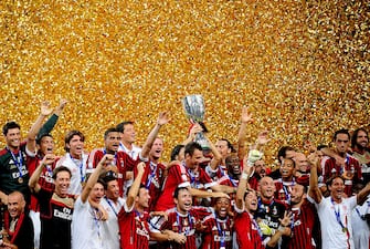 Football team players of AC Milan celebrate with the trophy after winning the Italian Super Cup 2011 match against Inter Milan at China's National Stadium, known as Bird's Nest, in Beijing on August 6, 2011. AC Milan beat Inter Milan 2-1. AFP PHOTO/Franko Lee (Photo credit should read Franko Lee/AFP via Getty Images)