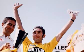 Belgian cyclist Eddy Merckx wearing the yellow jersey jubilates on the podium  on July 18, 1971 at the Velodrome la Cipale in Vincennes after winning the 20th stage of the Tour de France cycling race between Versailles and Paris. (Photo by - / AFP)        (Photo credit should read -/AFP via Getty Images)