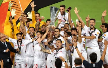 COLOGNE, GERMANY - AUGUST 21: Lucas Ocampos of Sevilla and his teammates lift the UEFA Europa League Trophy following their team's victory in the UEFA Europa League Final between Seville and FC Internazionale at RheinEnergieStadion on August 21, 2020 in Cologne, Germany. (Photo by Lars Baron/Getty Images)