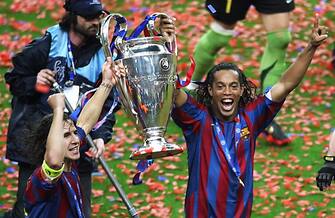 Saint-Denis, FRANCE:  Barcelona's Spanish defender and team captain Carles Puyol (L) and his Brazilian teammate Ronaldinho celebrate with the trophy after winning the UEFA Champion's League final football match against Arsenal, 17 May 2006 at the Stade de France in Saint-Denis, northern Paris. Barcelona won 2 to 1.  AFP PHOTO GABRIEL BOUYS  (Photo credit should read GABRIEL BOUYS/AFP via Getty Images)