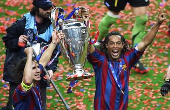 57640694 Saint-Denis, FRANCE: Barcelona's Spanish defender and team captain Carles Puyol (L) and his Brazilian teammate Ronaldinho celebrate with the trophy after winning the UEFA Champion's League final football match against Arsenal, 17 May 2006 at the Stade de France in Saint-Denis, northern Paris. Barcelona won 2 to 1. AFP PHOTO GABRIEL BOUYS (Photo credit should read GABRIEL BOUYS/AFP via Getty Images)