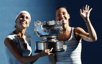 epa02553107 Gisela Dulko of Argentina (L) and Flavia Pennetta of Italy (R) hold their women's doubles final trophy after defeating Victoria Azarenka of Belarus and  Maria Kirilenko of Russia (unseen)  at the Australian Open Grand Slam tennis tournament in Melbourne, Australia, 28 January 2011.  EPA/DENNIS M. SABANGAN