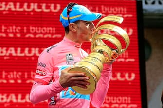 Italian cyclist Vincenzo Nibali kisses his trophy as he celebrates victory on the podium at the end of the 96th Giro d'Italia race, after the 206 km 21th and final stage from Riese Pio X to Brescia, on May 26, 2013, in Brescia, Italy. Italian Vincenzo Nibali secured his maiden Giro d'Italia title today as Britain's Mark Cavendish took his fifth stage win on the 21st and final leg into Brescia. AFP PHOTO / Luk Benies        (Photo credit should read LUK BENIES/AFP via Getty Images)