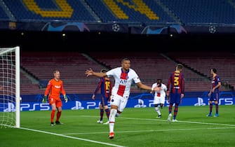 BARCELONA, SPAIN - FEBRUARY 16: Kylian Mbappe of Paris Saint-Germain celebrates after scoring his team's first goal during the UEFA Champions League Round of 16 match between FC Barcelona and Paris Saint-Germain at Camp Nou on February 16, 2021 in Barcelona, Spain. Sporting stadiums around Spain remain under strict restrictions due to the Coronavirus Pandemic as Government social distancing laws prohibit fans inside venues resulting in games being played behind closed doors.  (Photo by Alex Caparros - UEFA/UEFA via Getty Images)