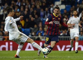 Barcelona's Argentinian forward Lionel Messi (R) vies with Real Madrid's Portuguese forward Cristiano Ronaldo during the Spanish league "Clasico" football match Real Madrid CF vs FC Barcelona at the Santiago Bernabeu stadium in Madrid on March 23, 2014. Barcelona won 4-3.   AFP PHOTO/ GERARD JULIEN        (Photo credit should read GERARD JULIEN/AFP via Getty Images)