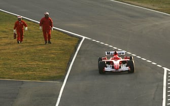 56657813 MUGELLO, ITALY - JANUARY 24: Italian firemen follow Michael Schumacher's 248 F1 car on the way to the pit lane after it broke down on the track while testing during the launch of the new Ferrari F1 car for the Season 2006 on January 24, 2006 in Mugello near Florence, Italy. (Photo by Vladimir Rys/Bongarts/Getty Images)
