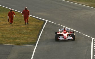 MUGELLO, ITALY - JANUARY 24: Italian firemen follow Michael Schumacher's 248 F1 car on the way to the pit lane after it broke down on the track while testing during the launch of the new Ferrari F1 car for the Season 2006 on January 24, 2006 in Mugello near Florence, Italy.  (Photo by Vladimir Rys/Bongarts/Getty Images)