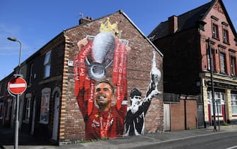 A mural of Jordan Henderson (L) lifting the Premier League trophy and former player Alan Hansen (R) is seen on the side of a house near to the stadium ahead of the English Premier League football match between Liverpool and Leeds United at Anfield in Liverpool, north west England on September 12, 2020. (Photo by Shaun Botterill / POOL / AFP) / RESTRICTED TO EDITORIAL USE. No use with unauthorized audio, video, data, fixture lists, club/league logos or 'live' services. Online in-match use limited to 120 images. An additional 40 images may be used in extra time. No video emulation. Social media in-match use limited to 120 images. An additional 40 images may be used in extra time. No use in betting publications, games or single club/league/player publications. /  (Photo by SHAUN BOTTERILL/POOL/AFP via Getty Images)