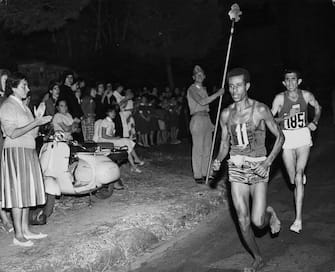 Abebe Bikila of Ethiopia, running barefoot, draws away from Abdesselem Rhadi of Morocco near the finish of the marathon at the 1960 Rome Olympics. He went on to win with a new Olympic record time of 2 hours 15 minutes 16 seconds.   (Photo by Central Press/Getty Images)