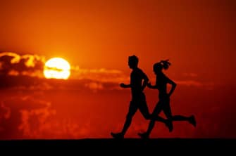 Model Released: Runners, silhouette at sunset (Photo by Nick Wilson/Getty Images)