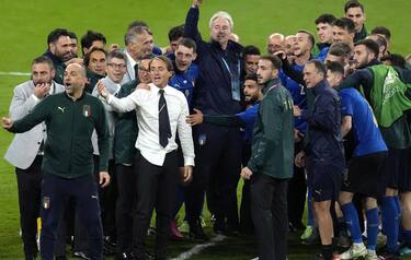 epa09327397 Italian head coach Roberto Mancini (white shirt) and the team celebrate after the UEFA EURO 2020 semi final between Italy and Spain in London, Britain, 06 July 2021. Italy won the game after penalty shoot-out.  EPA/Matt Dunham / POOL (RESTRICTIONS: For editorial news reporting purposes only. Images must appear as still images and must not emulate match action video footage. Photographs published in online publications shall have an interval of at least 20 seconds between the posting.)