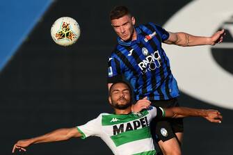 Sassuolo's German defender Jeremy Toljan (Bottom) and Atalanta's German defender Robin Gosens go for a header during the Italian Serie A football match Atalanta vs Sassuolo, played on June 21, 2020 at the Atleti Azzurri d'Italia stadium, behind closed doors as the country gradually eases its lockdown aimed at curbing the spread of the COVID-19 infection, caused by the novel coronavirus. (Photo by Miguel MEDINA / AFP) (Photo by MIGUEL MEDINA/AFP via Getty Images)