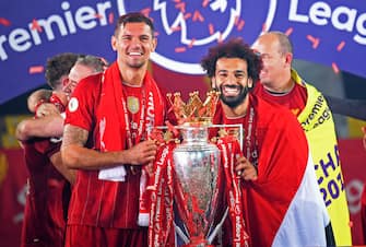 LIVERPOOL, ENGLAND - JULY 22: Dejan Lovren of Liverpool (L) and Mohamed Salah of Liverpool (R) pose for a photo with The Premier League trophy following the Premier League match between Liverpool FC and Chelsea FC at Anfield on July 22, 2020 in Liverpool, England. Football Stadiums around Europe remain empty due to the Coronavirus Pandemic as Government social distancing laws prohibit fans inside venues resulting in all fixtures being played behind closed doors. (Photo by Laurence Griffiths/Getty Images)
