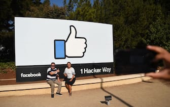 People pose for a photo in front of the Facebook "like" sign at Facebook's corporate headquarters campus in Menlo Park, California, on October 23, 2019. (Photo by Josh Edelson / AFP) (Photo by JOSH EDELSON/AFP via Getty Images)