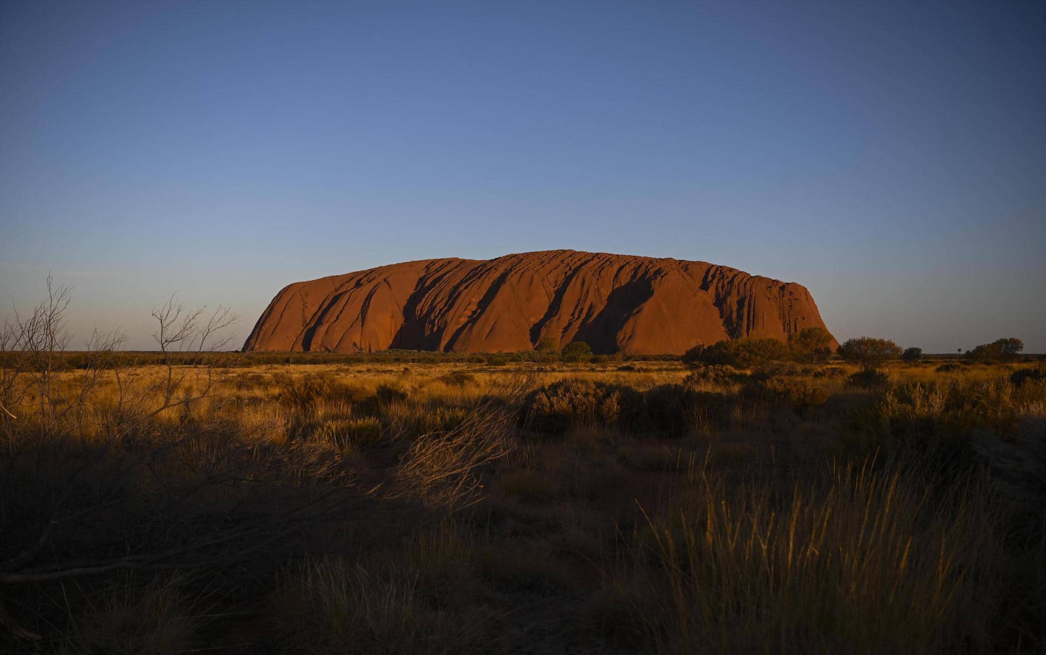epa07950719 Uluru, also known as Ayers Rock is seen during sunset at Uluru-Kata Tjuta National Park in the Northern Territory, Australia, 26 October 2019. On 26 October 2019, an Uluru climbing ban came into effect. The ban was initially announced on 01 November 2017 and was made by the traditional owners of the land.  EPA/LUKAS COCH AUSTRALIA AND NEW ZEALAND OUT