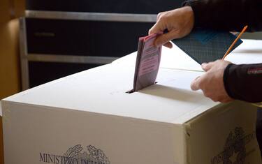 Una scheda elettorale viene messa nell'urna elettorale in un seggio di una scuola al centro di Roma, 26 maggio 2013.  ANSA/CLAUDIO ONORATI
