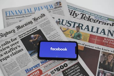 epa09020239 An illustration image shows a phone screen with the Facebook logo and Australian Newspapers at Parliament House in Canberra, Australia, 18 February 2021. Social media giant Facebook has moved to prohibit publishers and people in Australia from sharing or viewing Australian and international news content in response to Australia's proposed media bargaining laws.  EPA/LUKAS COCH AUSTRALIA AND NEW ZEALAND OUT