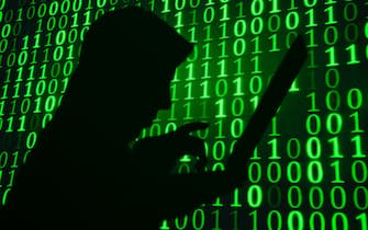 Computer hacker silhouette. Green binary code background 
