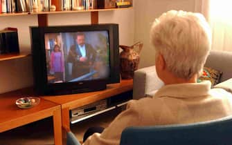 An elderly lady watches TV