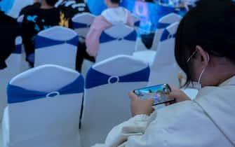 TIANJIN, CHINA - 2021/11/06: A girl is playing the video game of League of Legends on her mobile phone.  League of Legends (LoL), is a multiplayer online video game developed and published by Riot Games, very popular among Chinese young people.  (Photo by Zhang Peng / LightRocket via Getty Images)