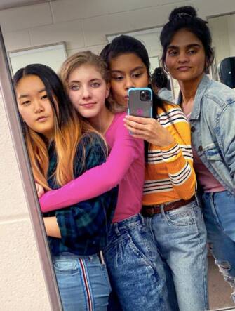 Quattro ragazze si fanno un selfie davanti a uno specchio
