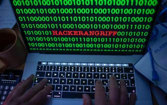 04 January 2019, Mecklenburg-Western Pomerania, Schwerin: ILLUSTRATION - The word "hacker attack" can be seen between the binary code on a laptop monitor. (posed photo) Photo: Jens Büttner/dpa-Zentralbild/ZB