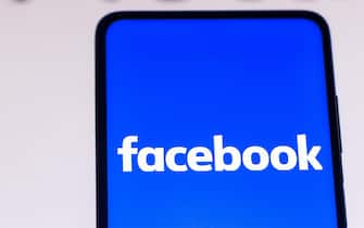 In this photo illustration the Facebook logo seen displayed on a smartphone with a Meta Logo in the background. (Photo by Rafael Henrique / SOPA Images/Sipa USA)