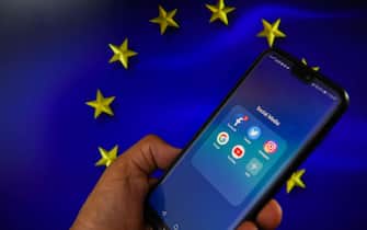 Un telefono con app social e sullo sfondo la bandiera europea