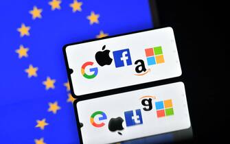 A phone with Big Tech logos on the European flag background
