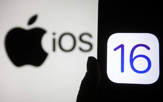 1235707352 UKRAINE - 2021/10/05: In this photo illustration, IOS 16 logo is seen on a smartphone screen with an Apple logo in the background. (Photo Illustration by Pavlo Gonchar/SOPA Images/LightRocket via Getty Images)