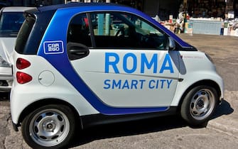 Rome smart city, Car2Go, car sharing, perpendicularly badly parked in the street, side view.  Environment transport.  Rome, Italy, Europe, EU.