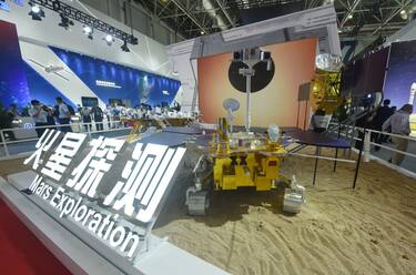ZHUHAI, CHINA - SEPTEMBER 29, 2021 - Visitors look at the Tianwen 1 orbiter and the Zhurong rover model at the AirShow in Zhuhai, South China's Guangdong Province, Sept. 29, 2021. On October 22, 2021, the China National Space Administration (CNSA) lunar Exploration and Space Engineering Center said the Tianyun-1 orbiter and the Zhurong rover had safely passed their first solar transit and resumed scientific exploration of Mars. (Photo credit should read Long Wei / Costfoto/Future Publishing via Getty Images)